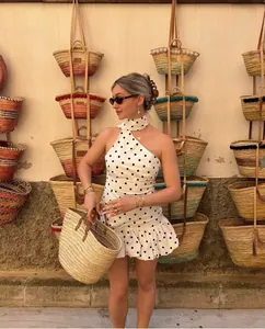Détail de la robe blanche à pois avec grand sac cabas en paille pour les vacances d'été