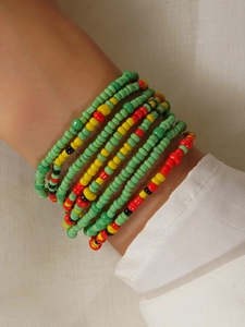 Close-up of colorful handmade bohemian seed bead body chains in green, yellow and red