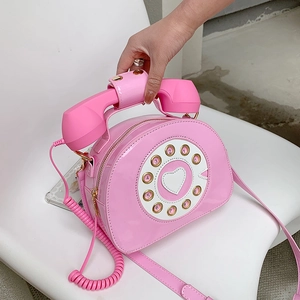 Detail of pink patent leather crossbody bag in retro creative telephone dial design