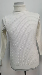 Dettaglio del maglione bianco a collo alto con trama a trecce in maglia in rilievo