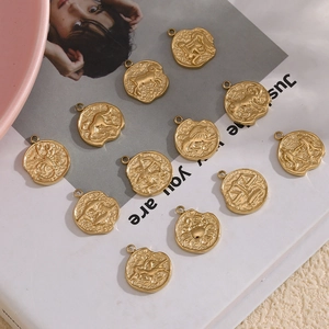 Set of 12 relief-carved 14K gold plated stainless steel zodiac charms on a magazine