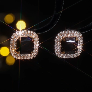 Macro detail of luxury square black gemstone earrings with sparkling halo in gold