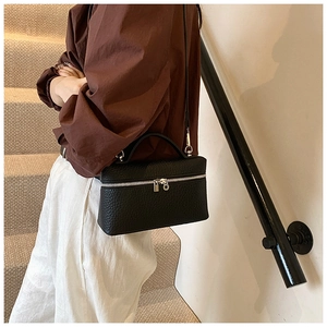 Close-up of black lychee grain box bag with silver zipper and long shoulder strap