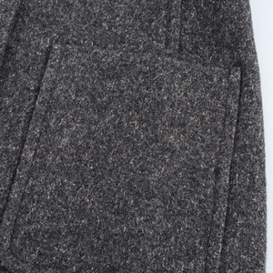 Macro shot of dark grey wool blend fabric texture and pocket stitching detail