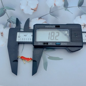 Macro view showing a red high heel charm measured with a digital caliper at 18.2mm