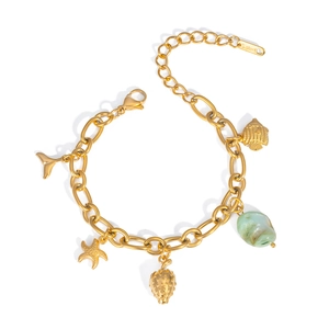 Detail of gold stainless steel bracelet with strawberry, starfish, and whale tail charms