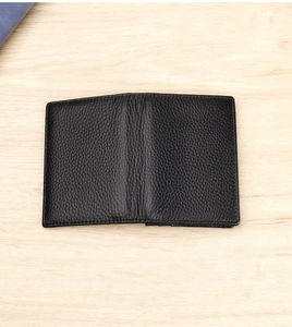 Detailed close-up of premium black lychee grain leather texture and stitching on business wallet