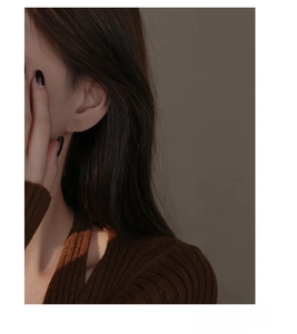 Close-up of S925 sterling silver hollow heart earrings worn on a female model ear