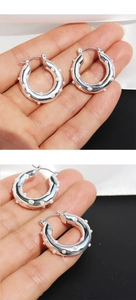 Close-up of silver hoop earrings inlaid with pearls shown from front and side views