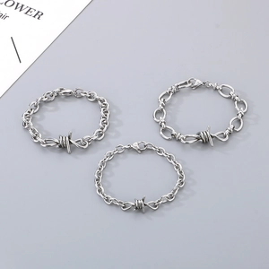Detailed close-up of three silver thorn bracelets with various metal chain link designs