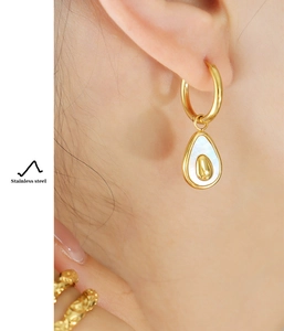 Close-up of elegant avocado shaped earring with shell inlay in polished gold finish