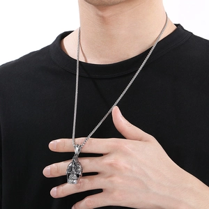 Close-up of gothic skull pendant with vintage patterns on a men's stainless steel chain