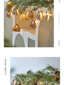 Detail of wooden Christmas tree LED string lights with snowman and Santa carvings