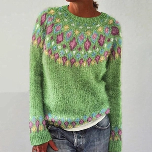 Detail of green knit sweater showing purple and yellow floral jacquard pattern on sleeves