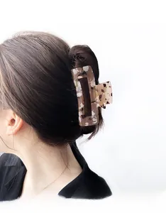 Detail of tortoise shell hair claw clip holding hair in a minimalist bun hairstyle