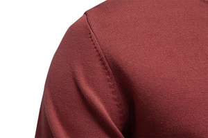 Vue macro du tricot bordeaux montrant les détails de couture et de finition de l'épaule