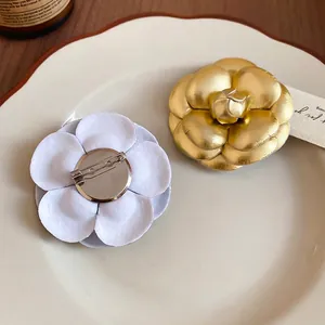Elegant leather camellia flower brooch set with gold metal and white fabric floral pins