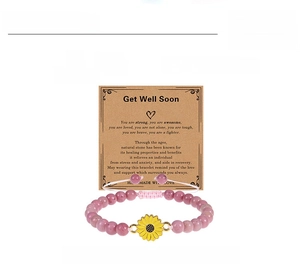 Detailed view of 6mm rhodochrosite bead bracelet with sunflower charm on a gift card