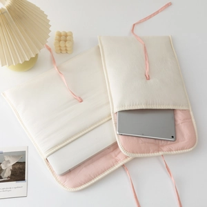 Quilted 13-inch laptop sleeve and iPad case with pink ribbon ties in cream finish