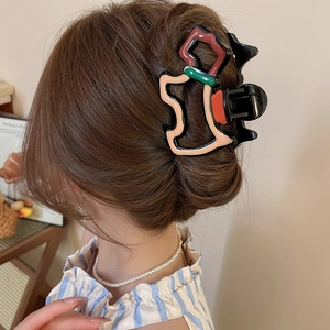 Grosse pince à cheveux en acrylique avec motifs d'étoiles géométriques colorés en gros plan