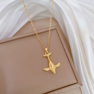 Close-up of luxury gold whale pendant with sparkling crystals on elegant silk fabric