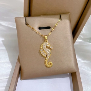 Luxury gold-plated seahorse pendant necklace with white zircons on silk background