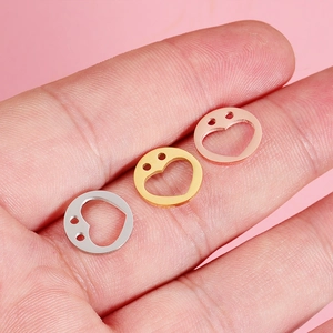 Polished 12mm stainless steel heart pendants in silver, gold, and rose gold on fingertips
