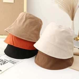 Minimalist solid color canvas bucket hats displayed in khaki, orange, and neutrals