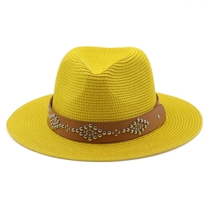 Close-up of yellow straw sun hat with brown faux leather band and silver metal studs