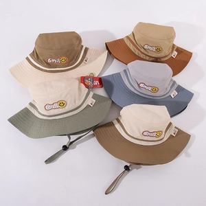 Detail of embroidered Smile and yellow face logo on cotton bucket hats with windproof cord
