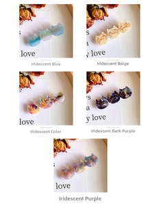Detail view of cat-shaped acetate hair clips showing five pearlescent colors and textures