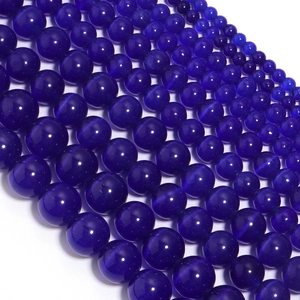 Macro shot of high-gloss dark blue cat eye beads for DIY jewelry and crafts