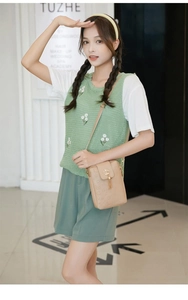 Detail of light brown leather mobile phone bag with heart embossing and tassel charm