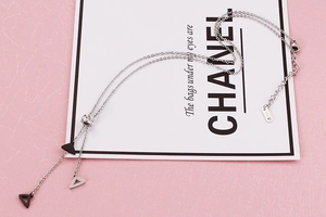 Detailed macro view of silver geometric triangle pendants and K14 engraved hallmark