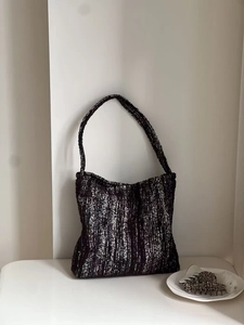 Close-up of black and white tweed texture on a retro minimalist shoulder tote bag