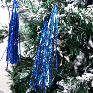 Blue tinsel garland with shiny laser sequins on a snowy Christmas tree decoration