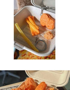 Macro view of realistic fried chicken and french fries keychain models in a white paper box