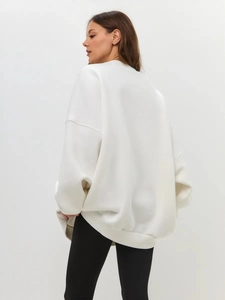 Rear side view of oversized white sweatshirt featuring dropped shoulders and relaxed fit