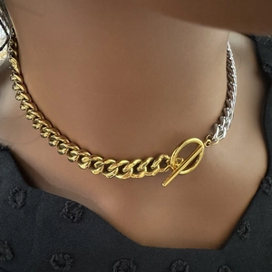 Close-up of dual-tone 18k gold and silver Cuban chain necklace with OT buckle