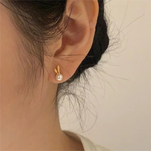 Detailed close-up of a 925 silver bunny pearl earring worn on the model ear