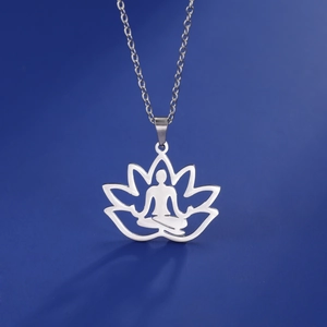 Detailed view of silver lotus meditation pendant with cutout yoga figure on blue background
