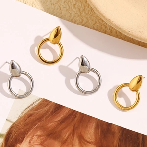 Macro detail of drop-shaped ring earrings in gold and silver finish with polished surface