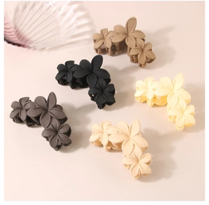 Detailed view of matte flower hair claws in khaki, black, grey, beige and yellow colors