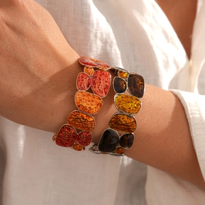 Detail of bohemian geometric resin bangles in warm autumn tones and retro textures