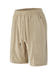 Detail of beige men's shorts showing textured waffle knit fabric and elastic drawstring waist