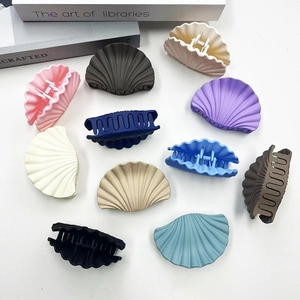 Chic shell-shaped hair claws in multiple colors arranged on a minimalist white surface