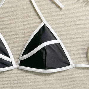 Detail view of black and white contrast bikini top with classic triangle cups and halter ties