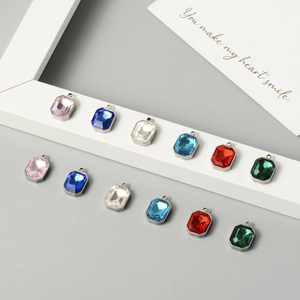 Macro shot of 12 colorful square crystal pendants with polished stainless steel frames