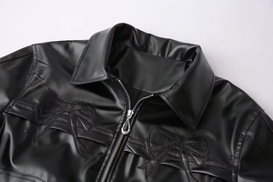 Gros plan sur la broderie nœud et la fermeture éclair d'une veste en similicuir noir