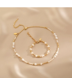Close-up of Baroque freshwater pearl necklace and bracelet set on champagne silk fabric